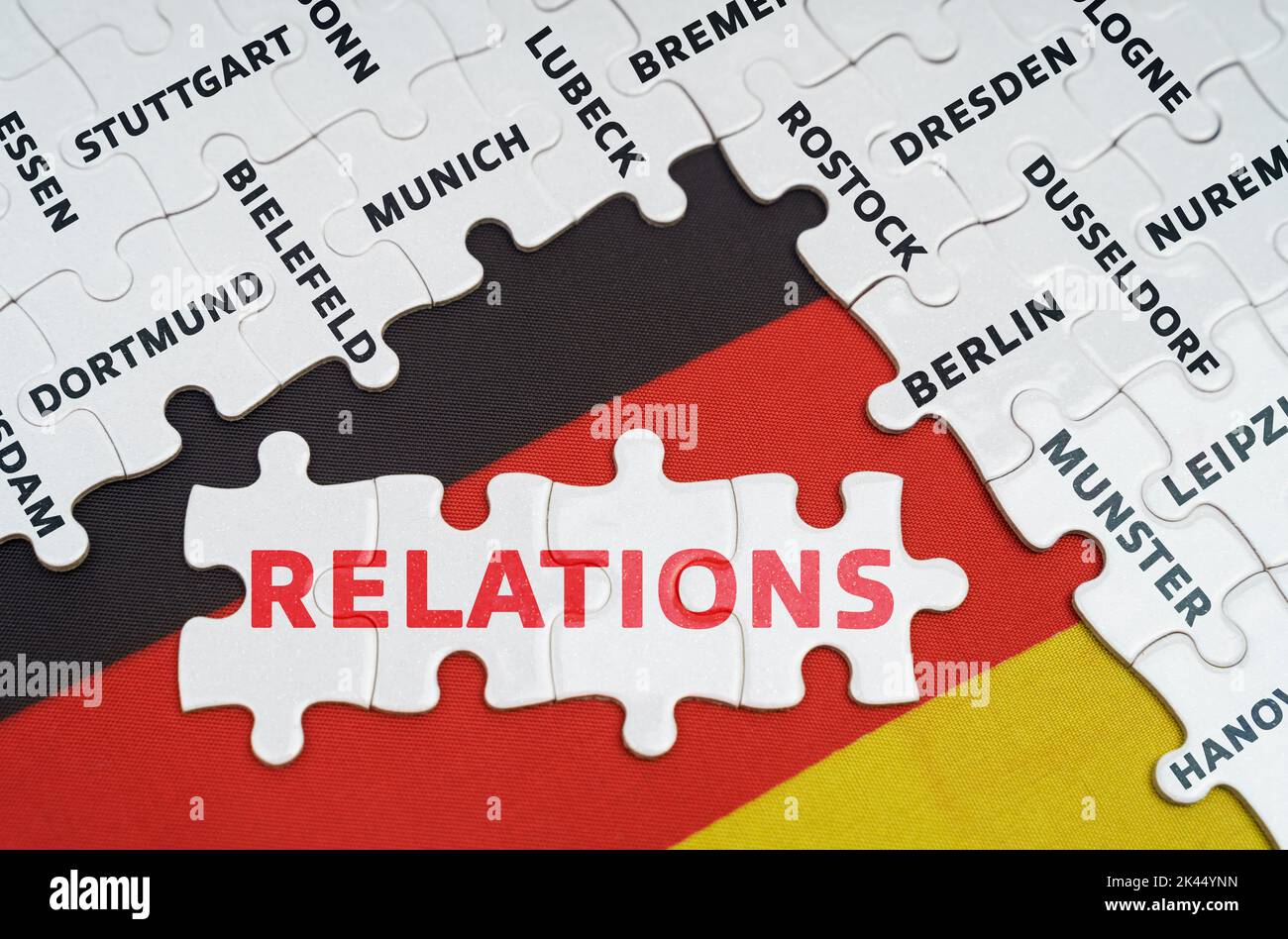 Nationales Konzept. Auf der Flagge Deutschlands gibt es Rätsel mit den Namen der Städte und Rätsel mit der Aufschrift - Beziehungen Stockfoto