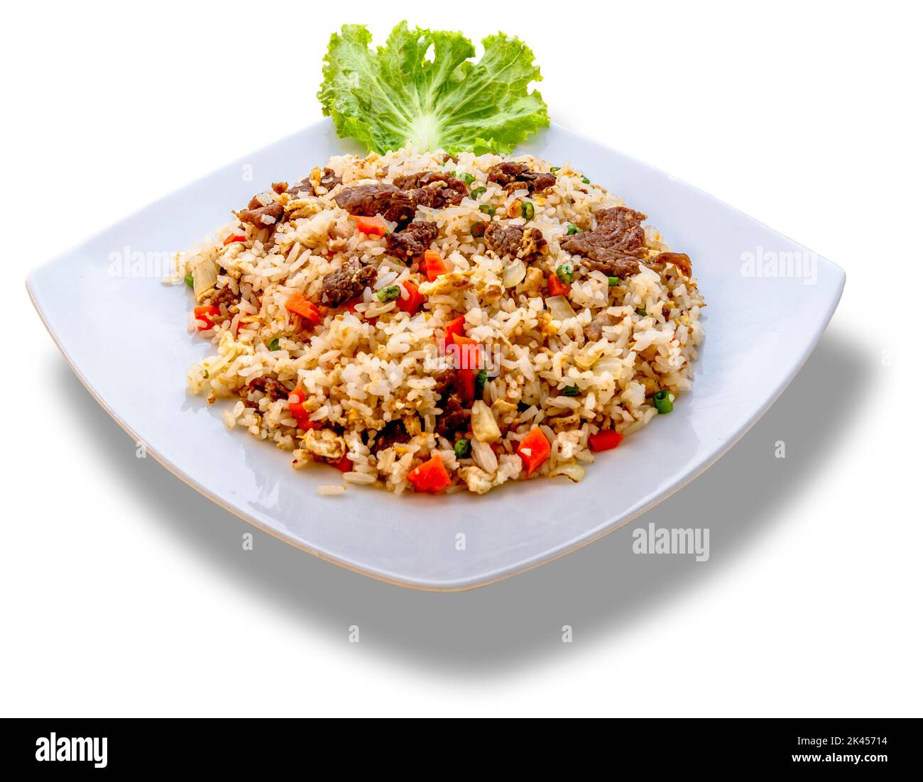 Ein weißer Teller mit gebratenem Khmer-Reis, garniert mit grünem Salat. Stockfoto