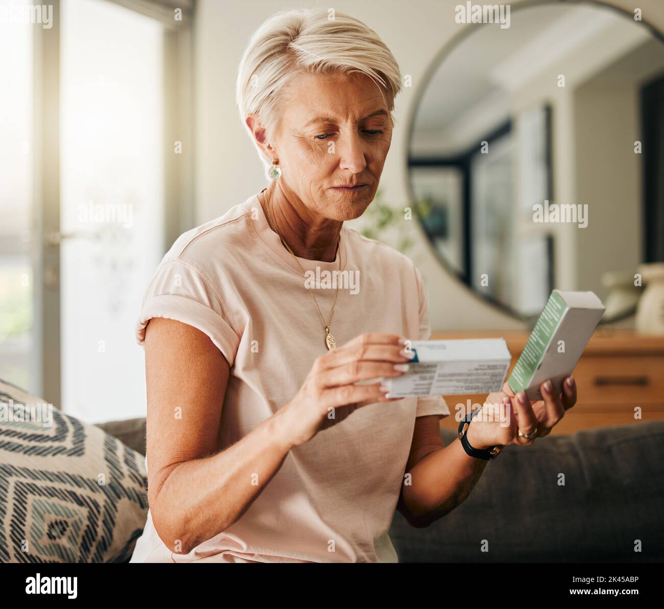 Ältere Frau, Medikamententabletten und Lesehinweise über Gesundheit, medizinisches Wohlbefinden und Apotheke Tablet-Box im Wohnzimmer des Hauses. Denken Stockfoto