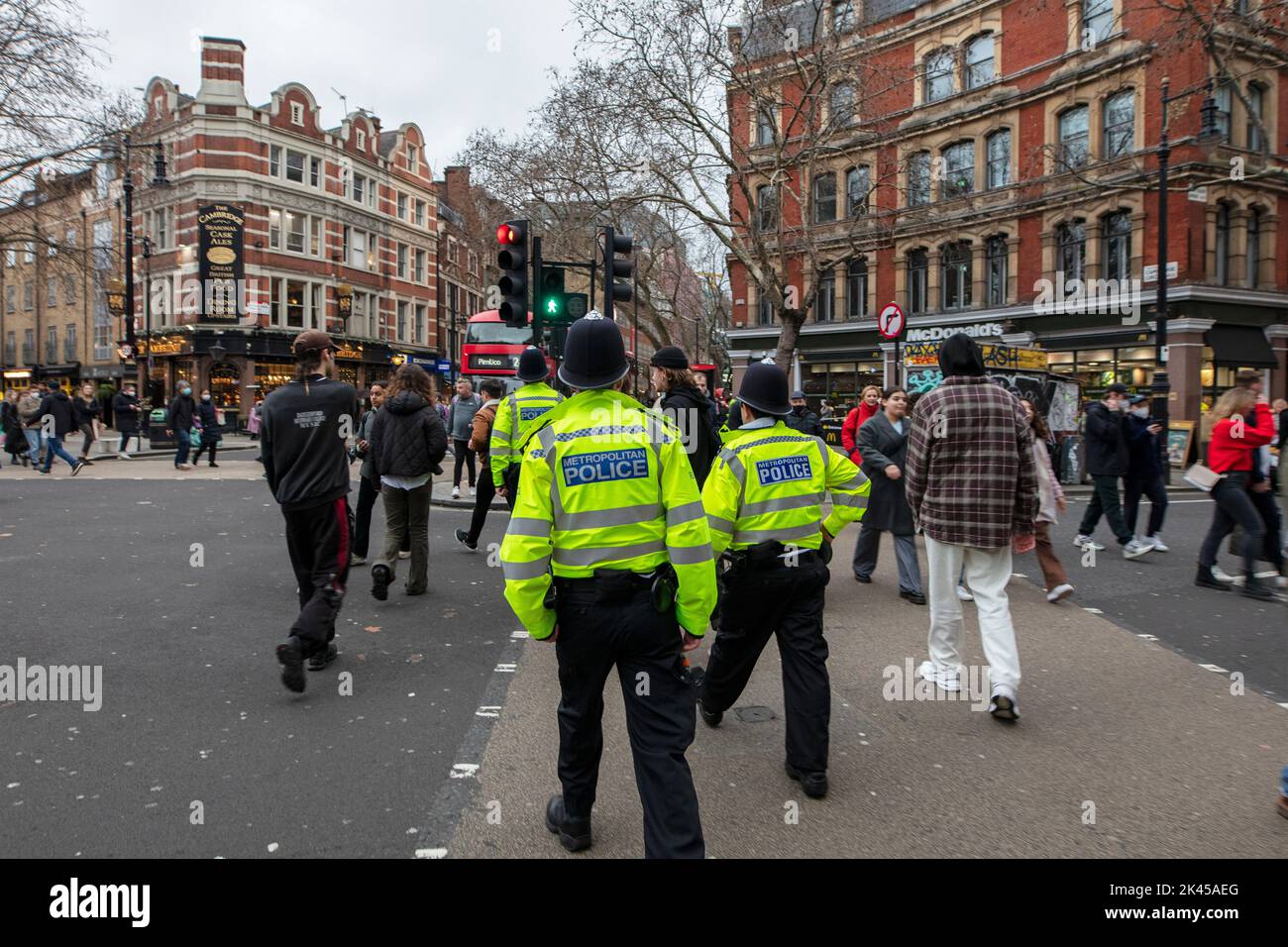 Polizisten, die in Sakkos über den Cambridge Circus im Zentrum Londons laufen Stockfoto