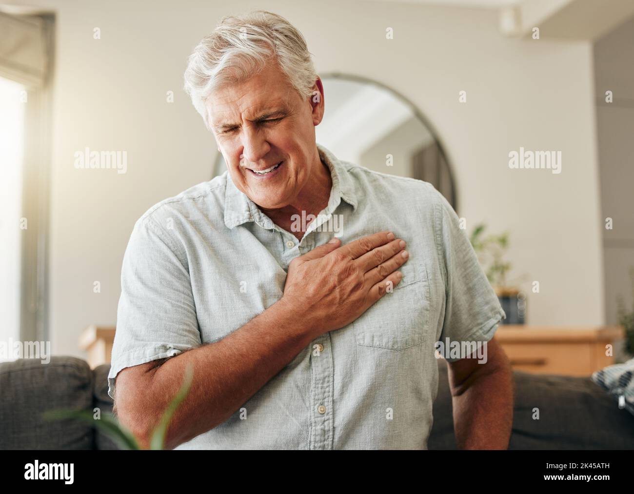 Leitender Mann, Herzinfarkt und Schlaganfall zu Hause wegen Gesundheitsrisiko im Notfall, Atemproblemen und kardiologischen Unfällen. Kranke ältere Männer mit Brustschmerzen Stockfoto