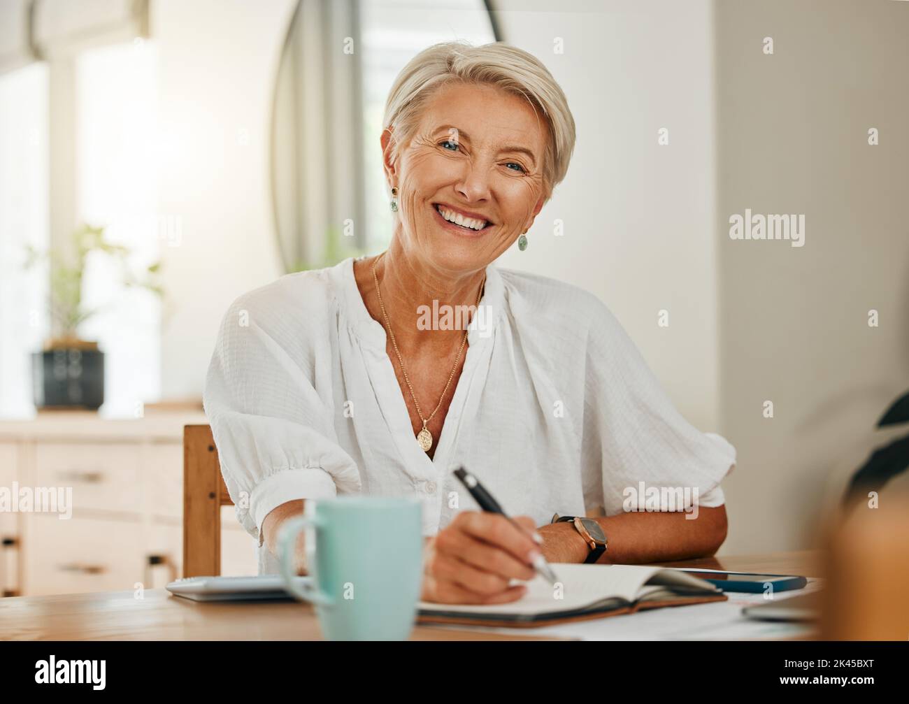 Freiberufliche Autorin, ältere Frau und schreiben im Notizbuch oder Planer glücklich fühlen, entspannen und genießen Ruhestand kreativ zu sein und zu Hause organisiert Stockfoto