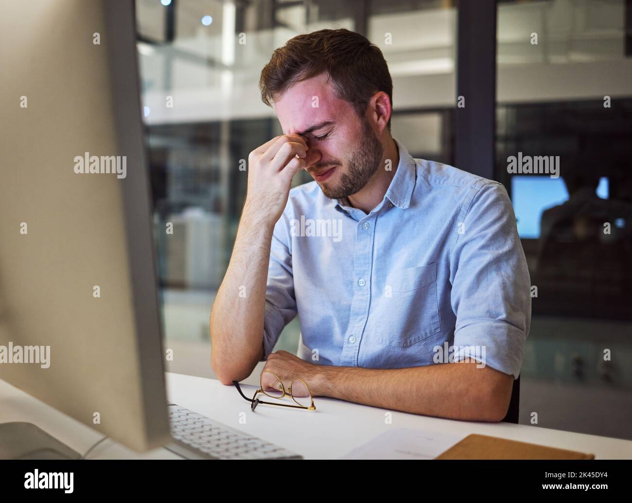 Burnout, Stress und müde Geschäftsmann mit psychischen Problemen kämpfen während der Arbeit Überstunden in einem Büro. Depressionen, Kopfschmerzen und Frustration Stockfoto