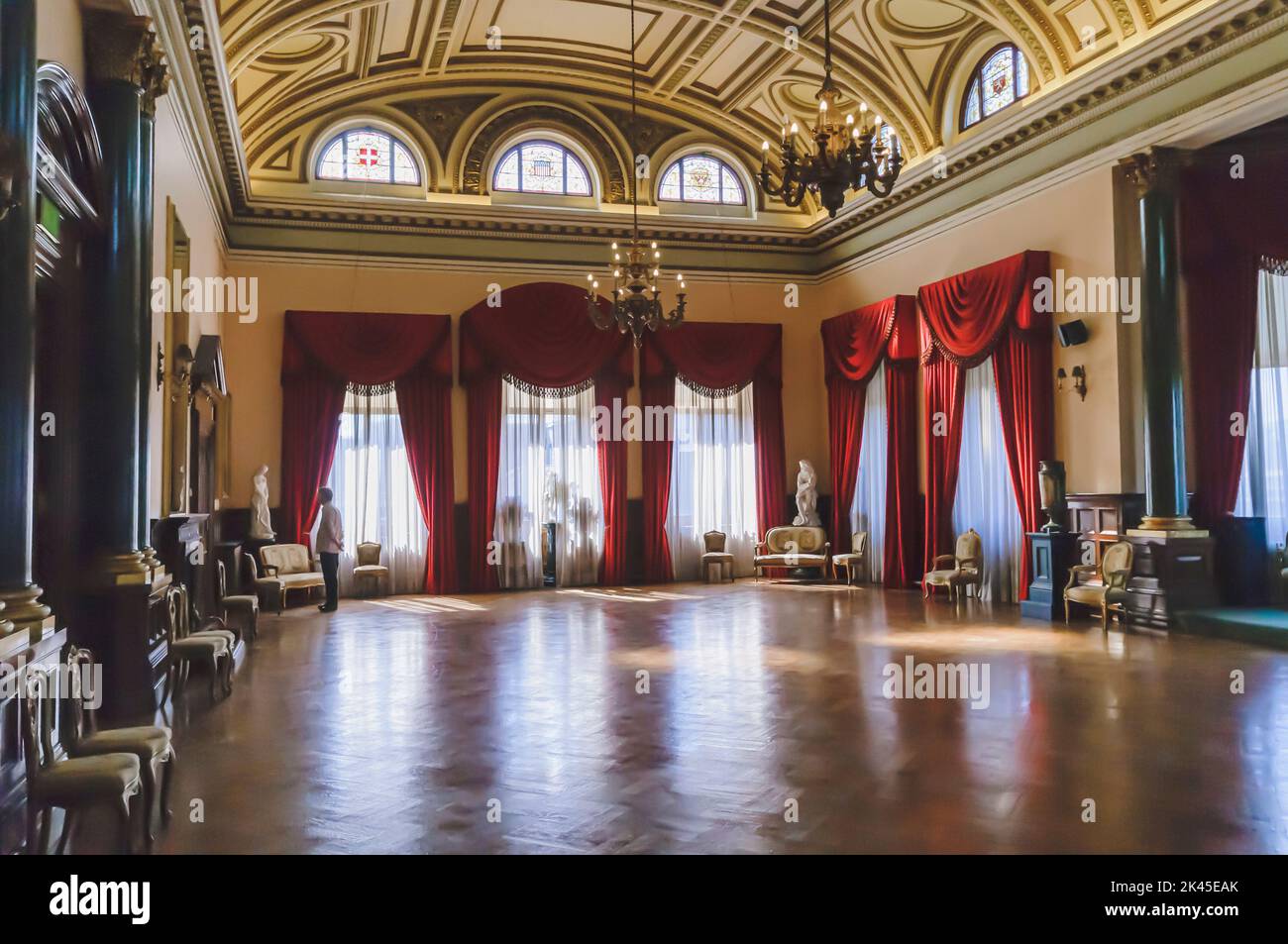 Grand Victorian Hall/Ballroom mit Holzparkettboden, kunstvollen Vorhängen und Kronleuchtern. Stockfoto