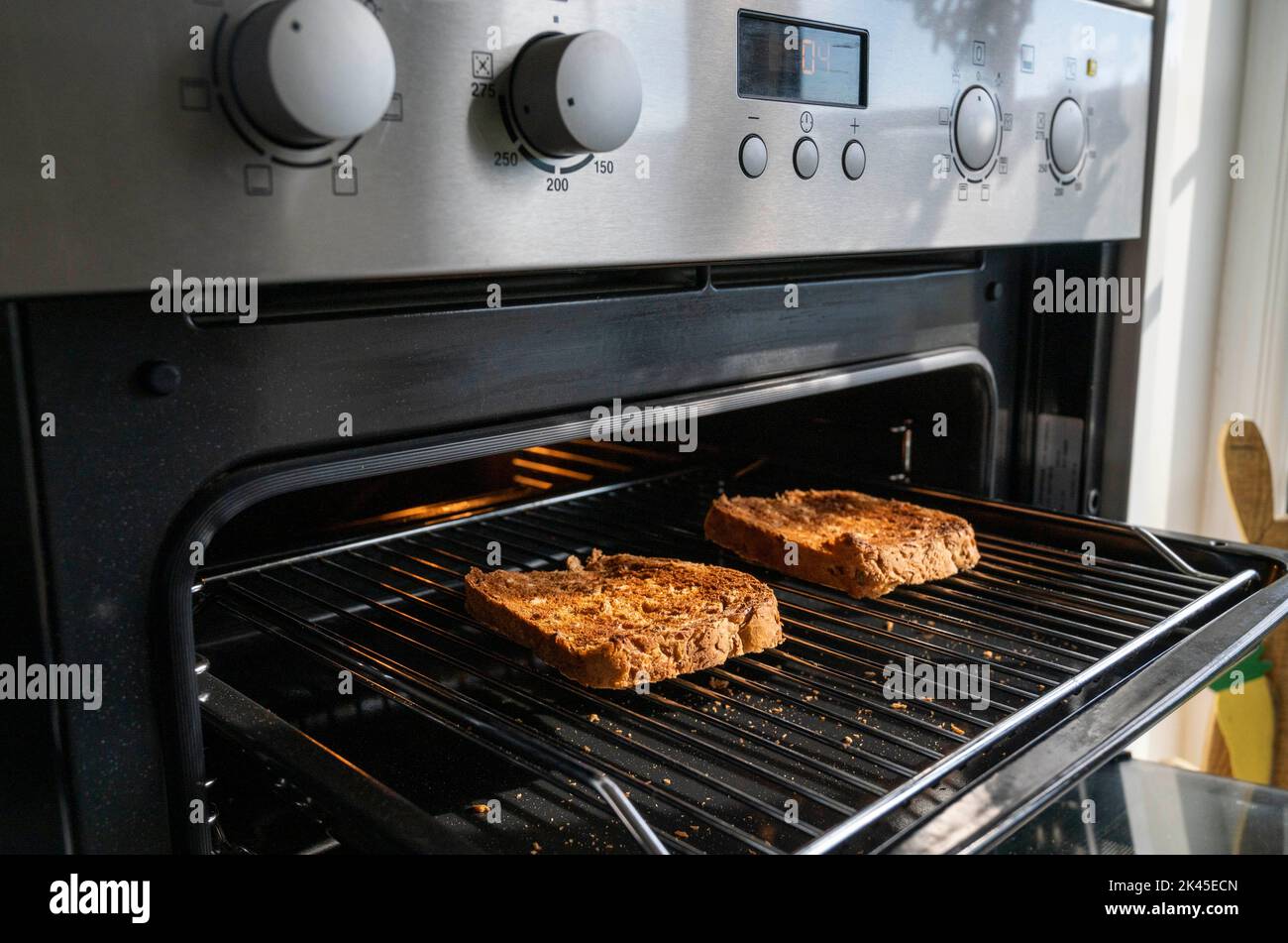 Toast mit braunem Getreidebrot unter einem elektrischen Grill in der Küche Stockfoto