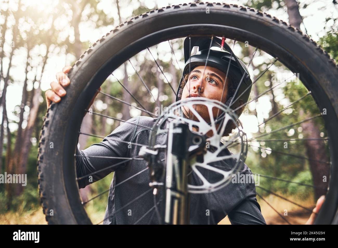Fahrrad, Rad und Reifen im Wald mit Mann beheben Problem in Zoom oder Nahaufnahme der Felge. Radfahrer, Fahrrad und im Wald gebrochen, während auf Training, Fitness und Stockfoto