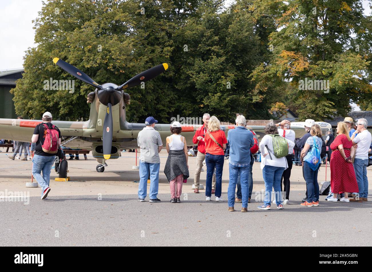 Menschen, die ein altes spitfire-Flugzeug aus dem Jahr WW2 betrachten, das auf einer Flugschau im Imperial war Museum, Duxford UK ausgestellt ist Stockfoto