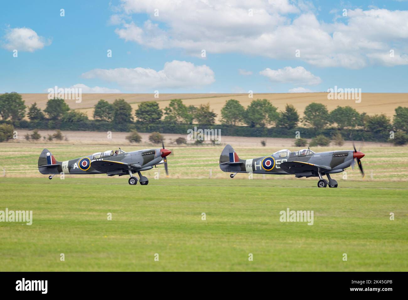 WW2 Flugzeuge - zwei Spitfires starten von der Startbahn im Imperial war Museum, Duxford Cambridgeshire UK Stockfoto