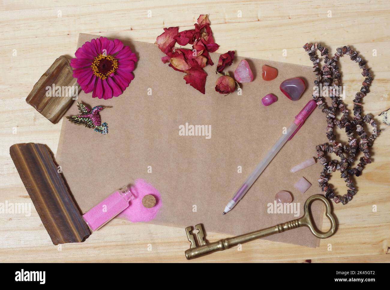 Rosa Blume mit rosa Steinen und Messing Schlüssel auf alten Papier Pink Thema Hintergrund Stockfoto
