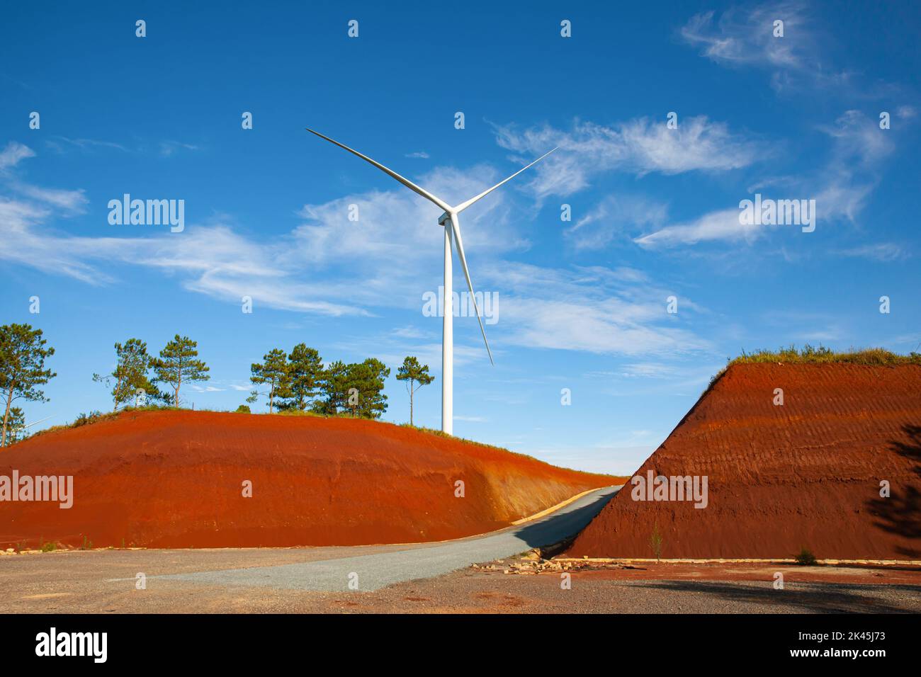 Erneuerbare Energien Windkraftanlagen Windmühle isoliert am schönen blauen Himmel und auf dem roten Sand in Da Lat Stadt, Lam Dong, Vietnam Stockfoto