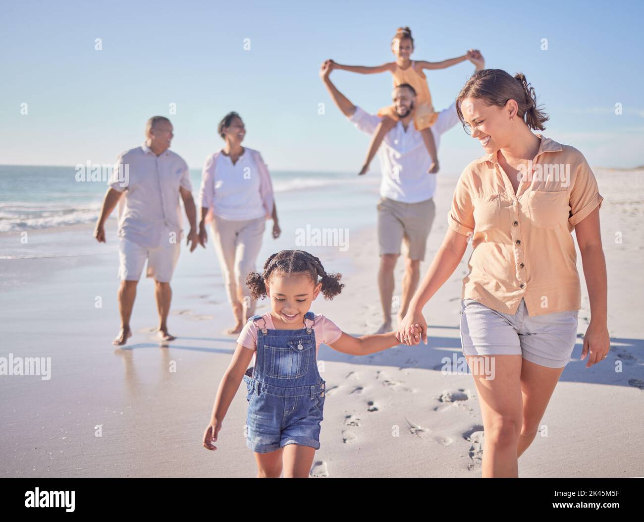 Familie, Mutter und Mädchen halten sich am Strand in den Sommerferien