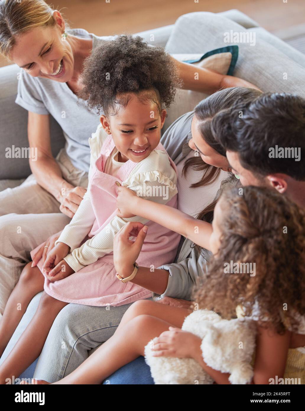 Entspannen, lieben und große Familie mit Adoptionskindern, die sich mit Eltern und Großmutter zu Hause verbinden. Glückliche schwarze Kinder, die sich mit kaukasischem Vater und Mutter ausruhen Stockfoto