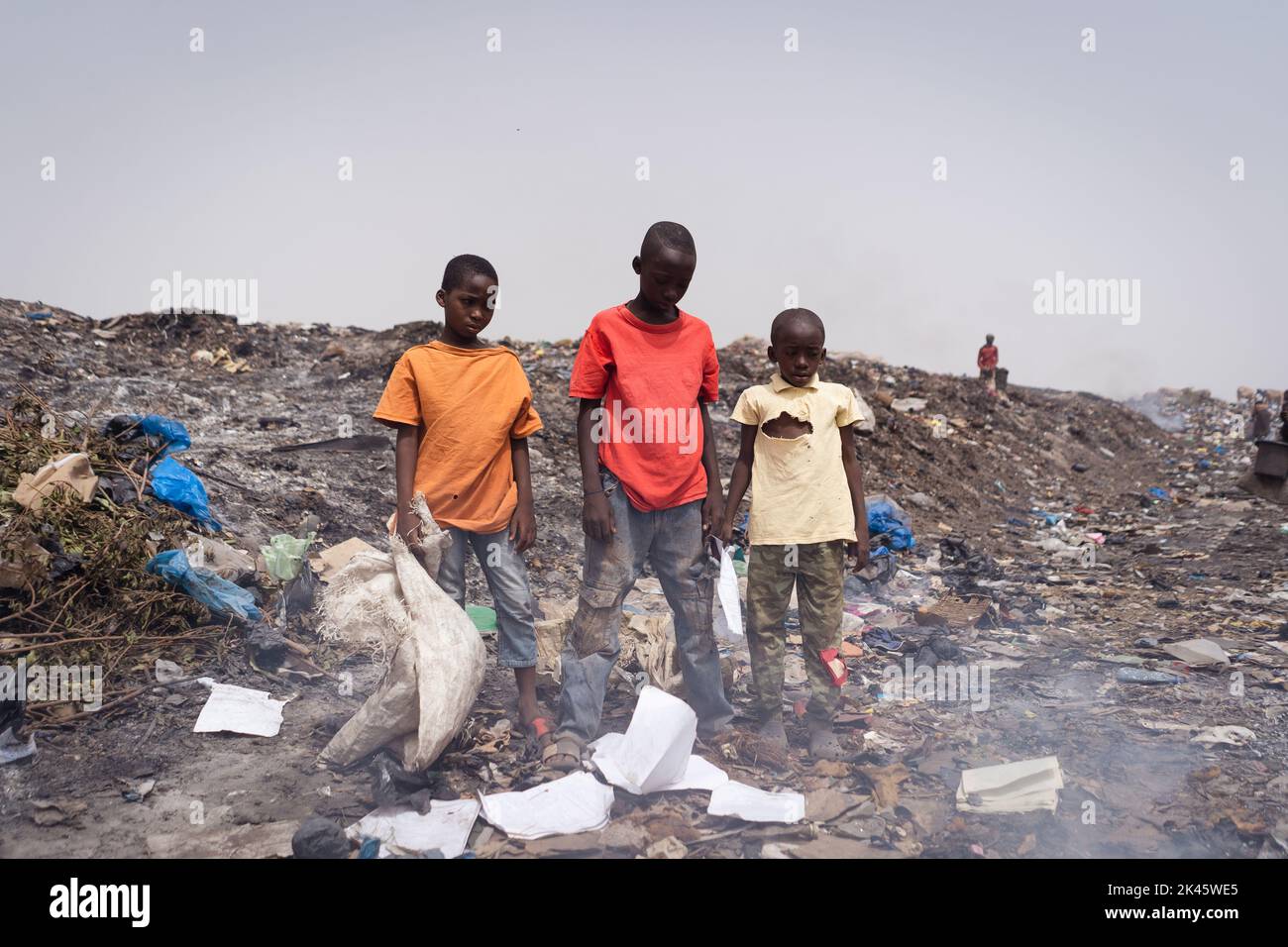 Drei einsame und arme Kinder afrikanischer Jungen, die auf einer Mülldeponie auf einer Deponie stehen Stockfoto