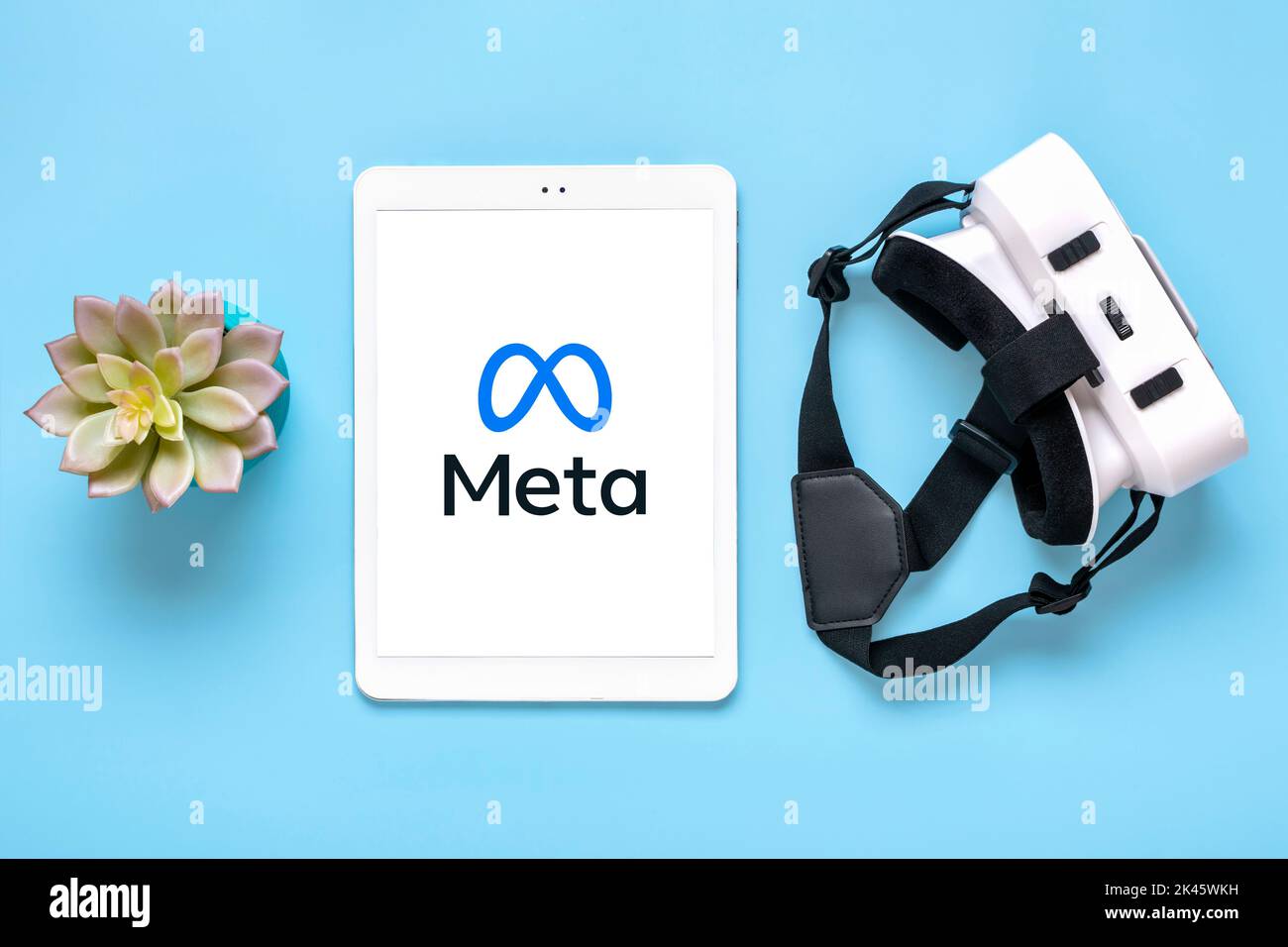 April 2022, Kanada. Weißes Tablet mit Meta-Logo-Bildschirm auf digitalem Display, VR-Brille für Virtual-Reality-Spiele auf blauem Hintergrund Rebranding von Social Media Facebook. Stockfoto