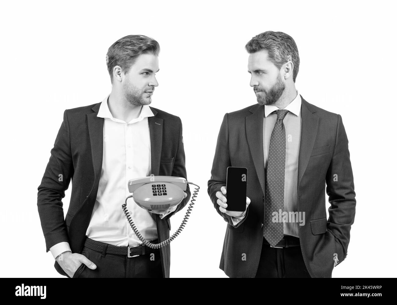 Professionelle Männer halten Telefon und Mobiltelefon isoliert auf weißem, Kommunikation Stockfoto