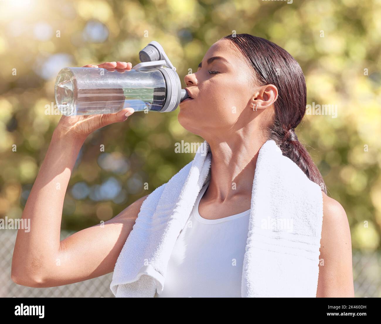 Frau, Sport treiben und trinken Sie Wasser, während Sie im Sommer laufen oder draußen trainieren, um sich fit zu machen. Lady, Workout und Flasche für die Hydratation in Sonne, Läufer und Stockfoto