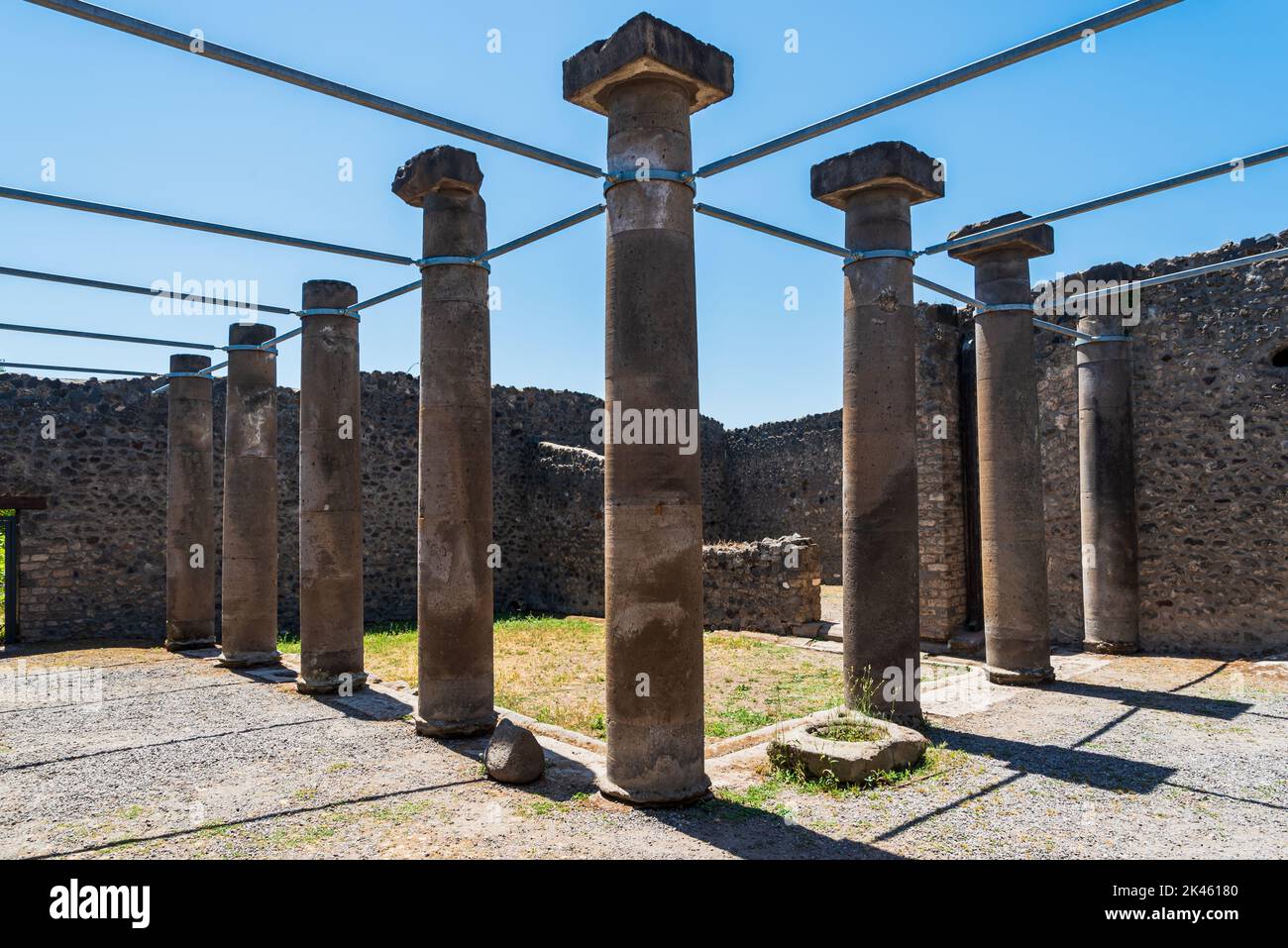 Alte römische Säulen, die von einer eisernen Struktur in den Ruinen von Pompeji getragen wurden Stockfoto