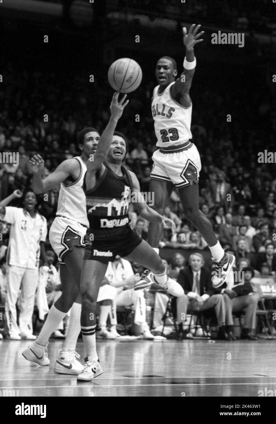 NBA-Superstar Michael Jordan von den Chicago Bulls fliegt, um einen Schuss während der Spielaktion im Jahr 1985 zu blockieren. Stockfoto