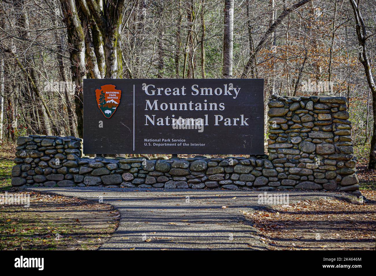 Great Smoky Mountains National Park Schild an einer Steinmauer mit der NPS-Pfeilspitze in einem Herbstwald. Stockfoto