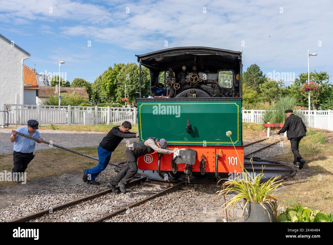 Eisenbahner bedienen manuell einen Drehteller, um eine Dampflokomotive umzudrehen. Stockfoto