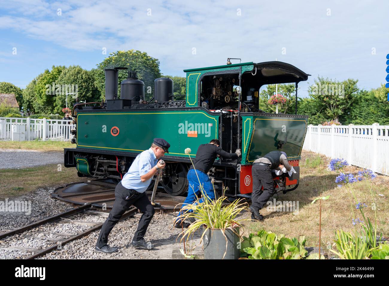 Eisenbahner bedienen manuell einen Drehteller, um eine Dampflokomotive umzudrehen. Stockfoto
