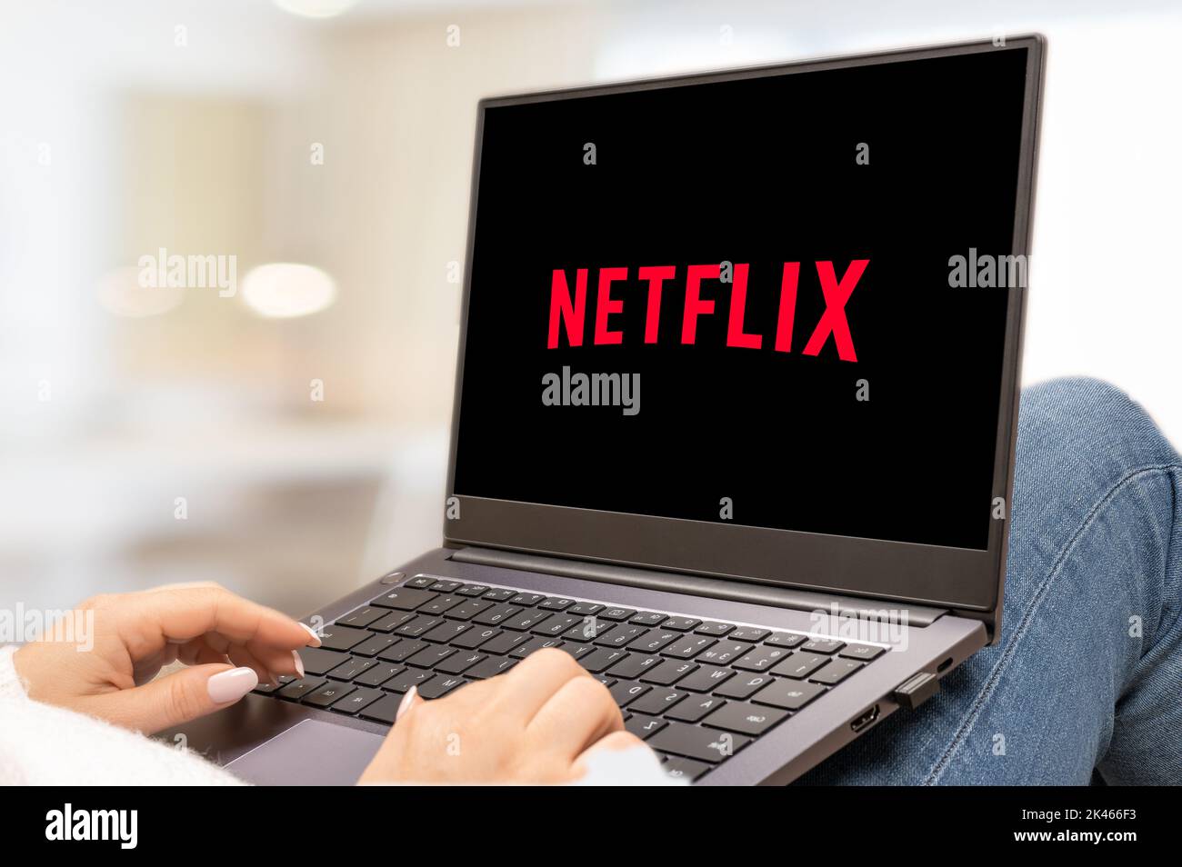 USA, NEW YORK 30. September 2022: Laptop-Computer mit Logo von Netflix, einem amerikanischen Mediendienstleister. Frau mit Laptop und netflix-Logo Stockfoto