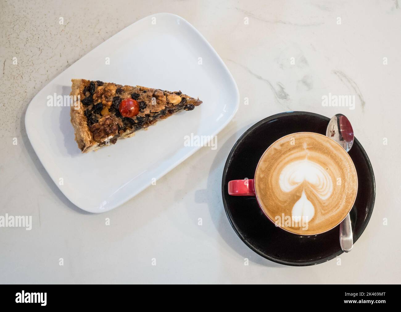 Eine Scheibe Ecclefechan Tart auf einem weißen Teller mit einer Tasse Kaffee Stockfoto