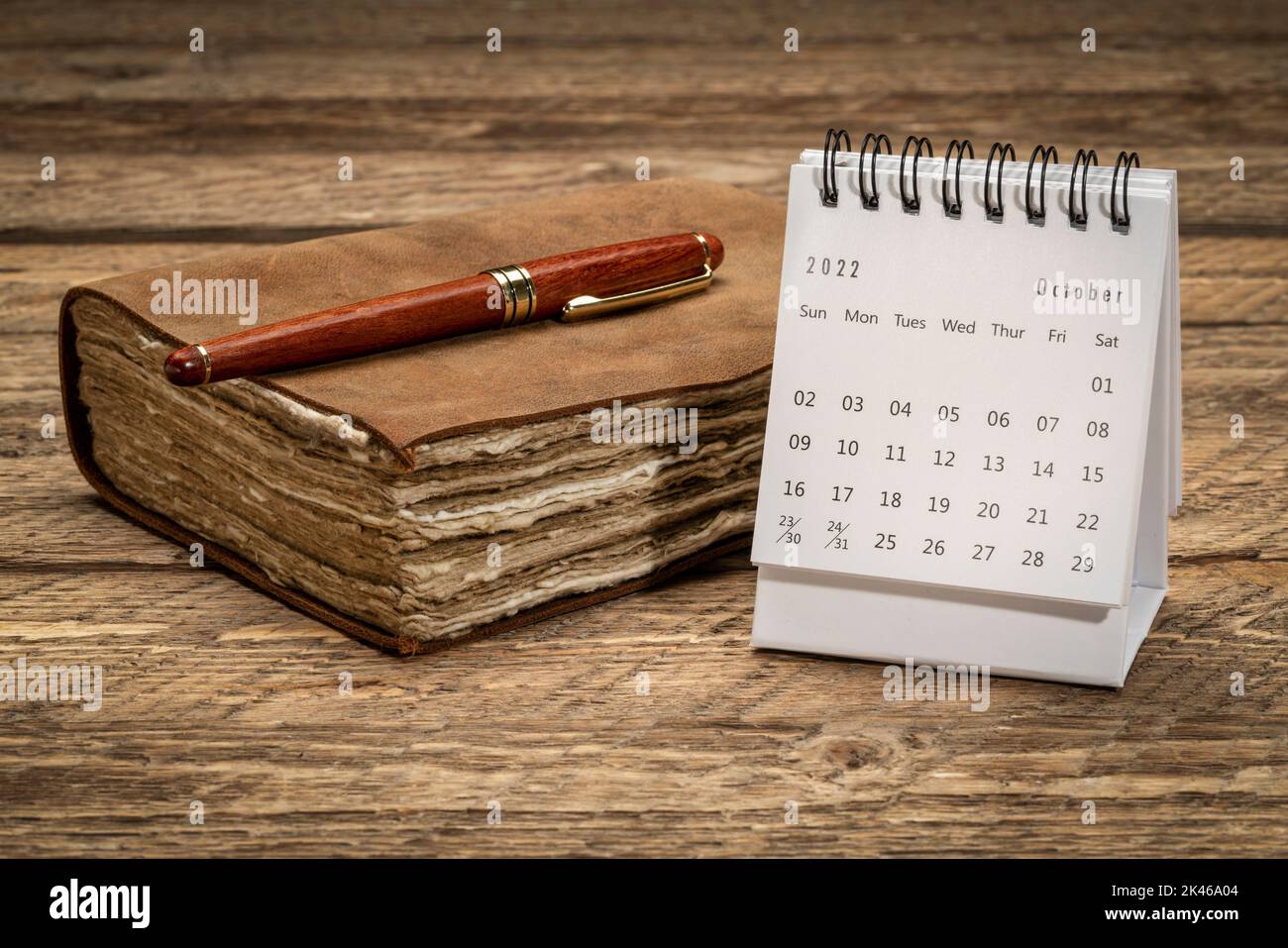 Oktober 2022 - kleiner Tischkalender gegen rustikales Holz mit Retro-Journal, Zeit- und Geschäftskonzept Stockfoto
