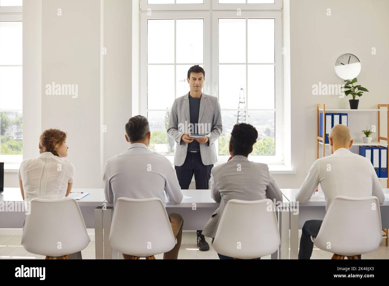 Mann Lehrer Couch lehrt kommuniziert mit einer Gruppe von erwachsenen Studenten während des Vortrags. Stockfoto