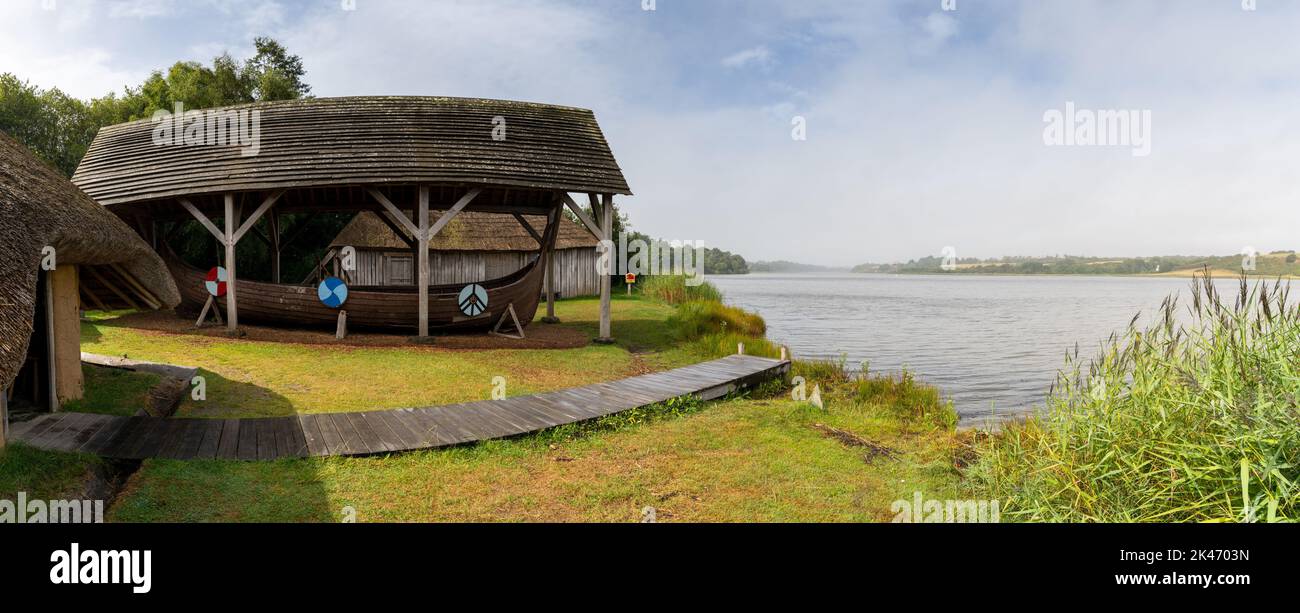 Wexford, Irland - 18. August 2022: Typisches Viking Long House mit einem rekonstruierten Boot am Ufer des Flusses Slaney im Irish National Heritag Stockfoto