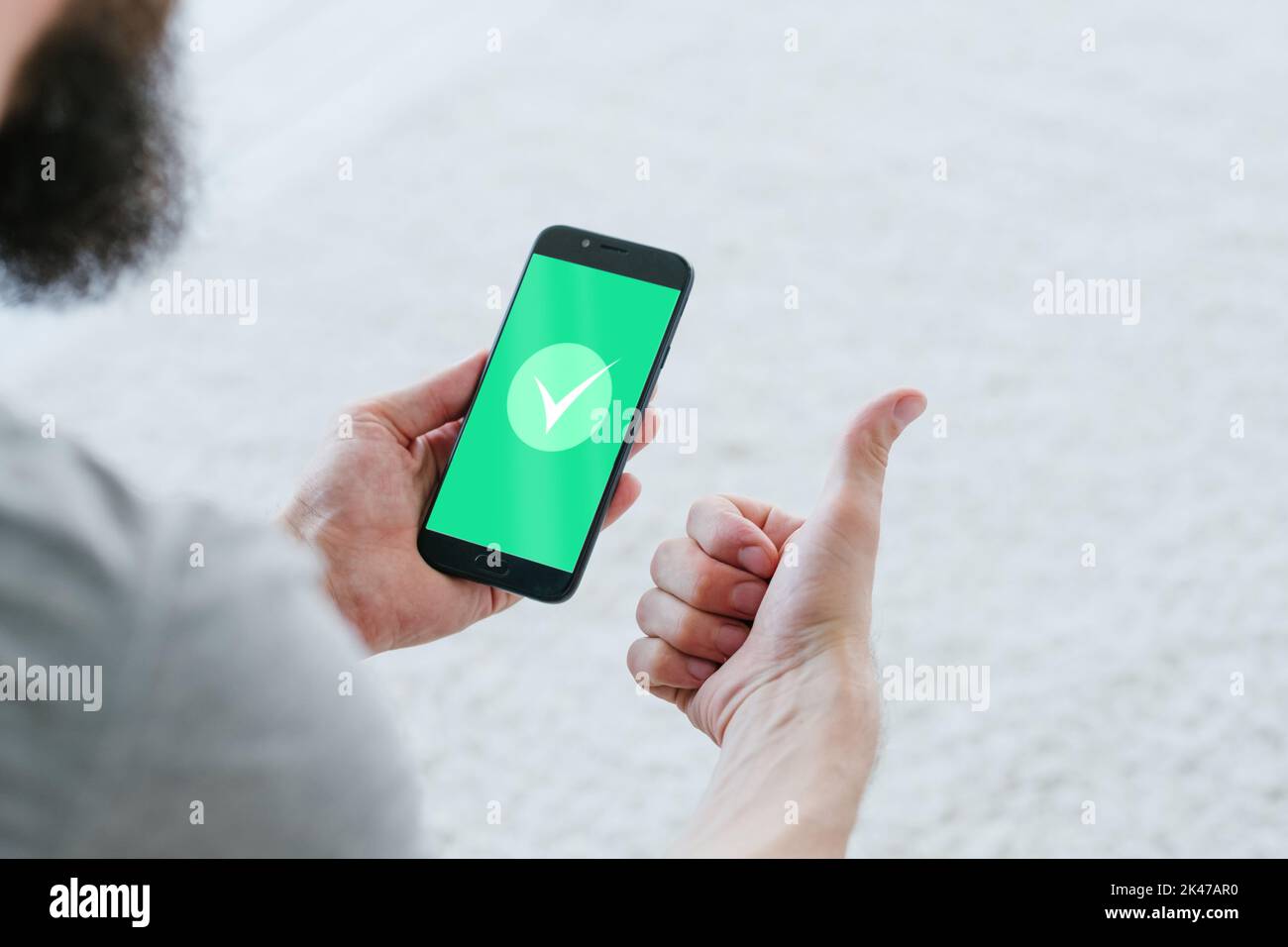 Kontaktlose Bezahlung. Status genehmigt. Erfolgreiche Datenüberprüfung. Sicherheit persönlicher Daten. Zufriedener männlicher Benutzer, der den Daumen bis zum grünen markiert Stockfoto