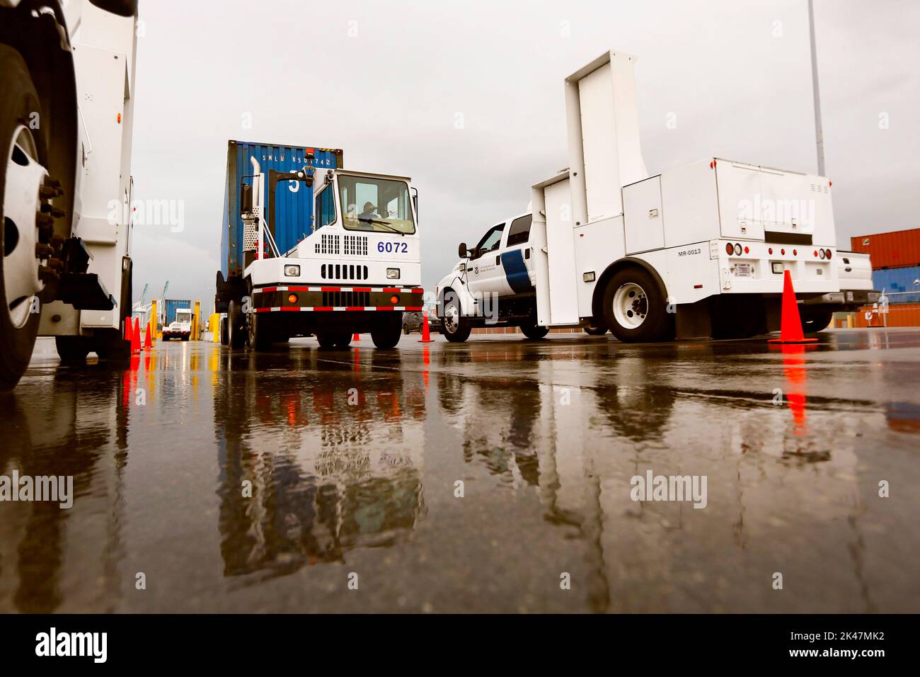 Ein von einem Hafenfahrzeug gezogener Transportcontainer wird von LKW-montierten Strahlungserkennungssystemen gescannt, die von US-Zoll- und Grenzschutzbeamten im Hafen von Miami in Miami, Florida, betrieben werden., 07. Dezember 2015. US CBP Foto von Glenn Fawcett Stockfoto