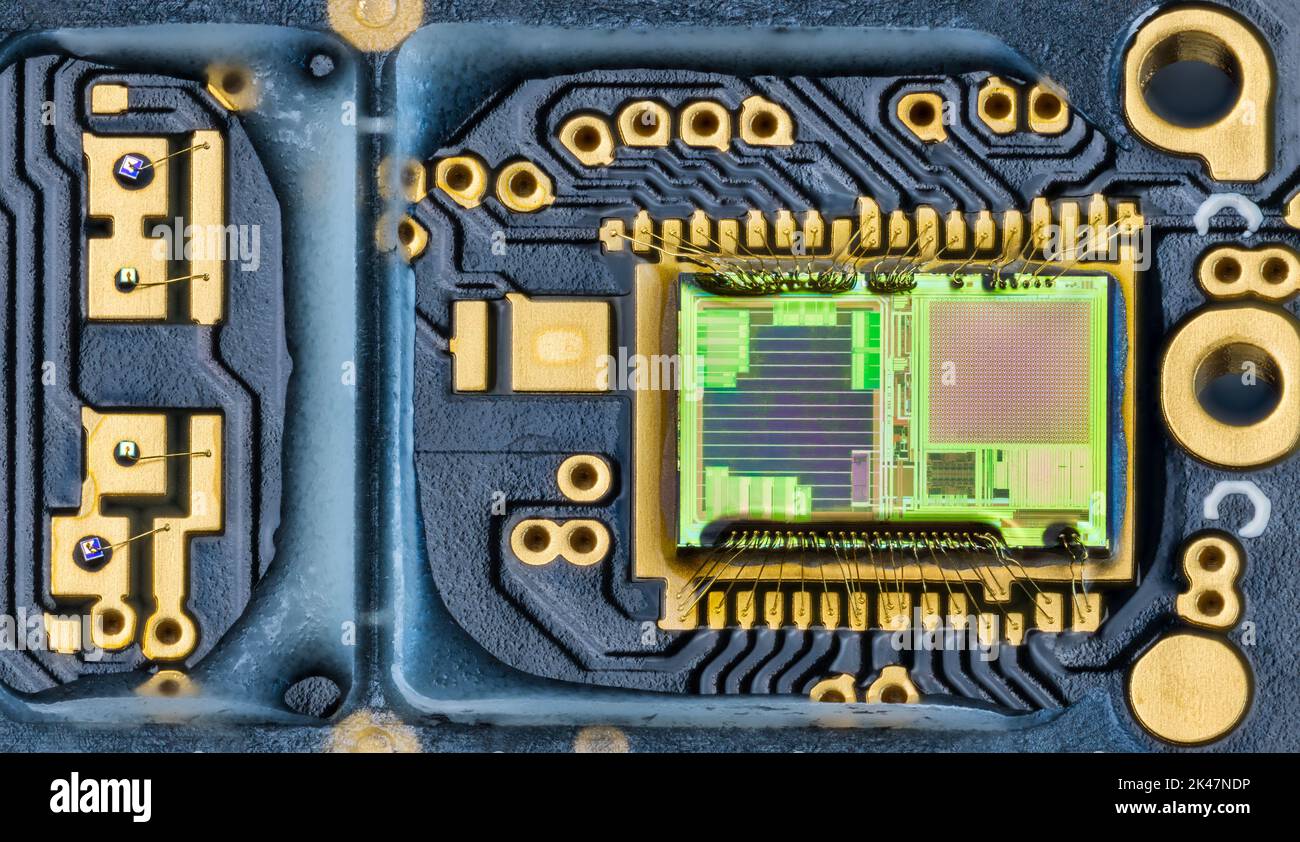 Nahaufnahme der grünen Matrize im integrierten Schaltkreis der optischen Computermaus. Elektronisches Photodiodenarray, Golddrähte auf blauer Leiterplatte. Mikroelektronik. Stockfoto