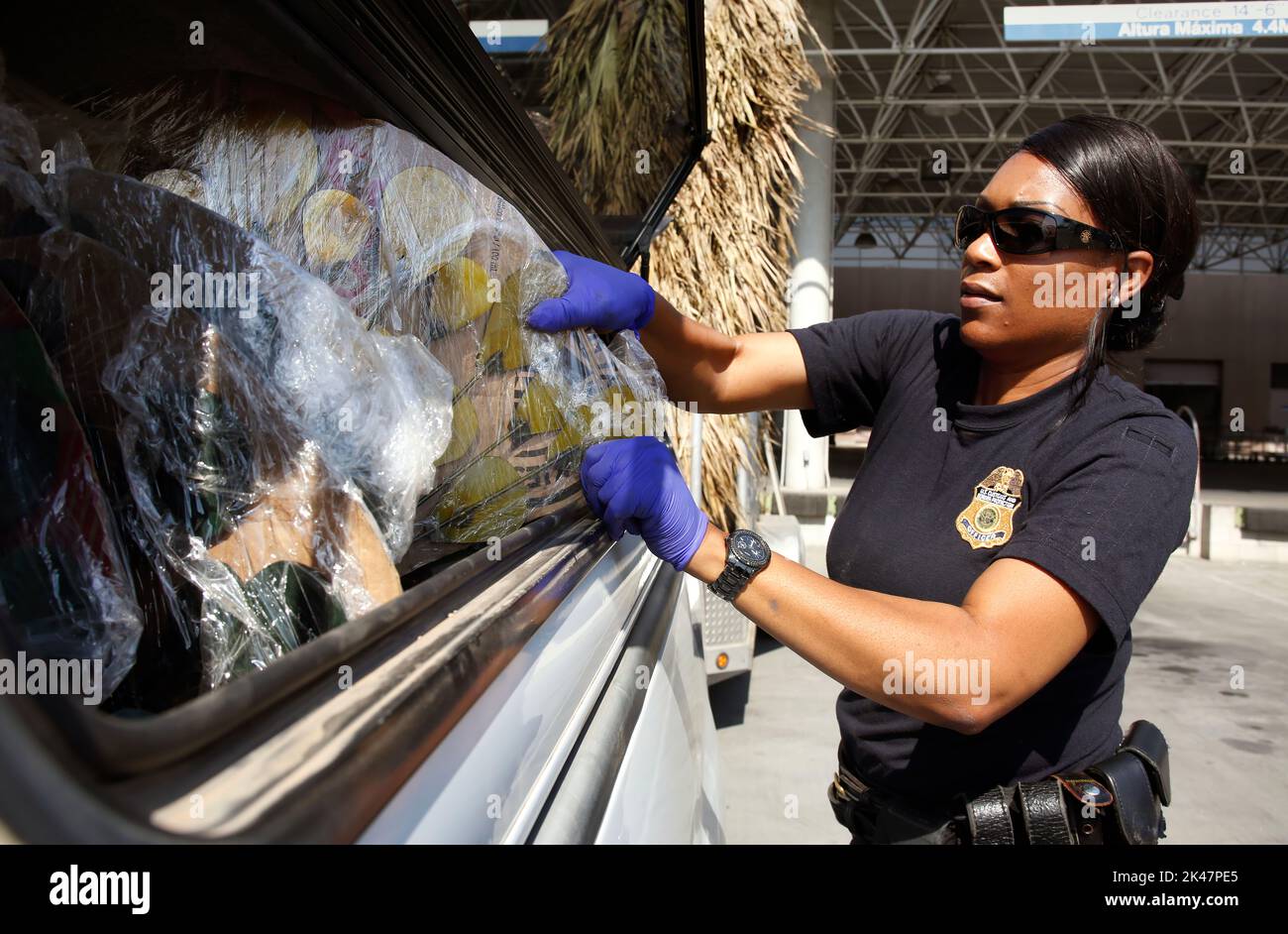 US-Zoll- und Grenzschutzbeamter greift in das Fenster eines Pickup-Trucks, um eine Lieferung von dekorativen Produkten zu überprüfen, die am Einreisehafen von Otay Mesa, 23. Juni 2016, in die USA verschifft werden. CBP-Foto von Glenn Fawcett Stockfoto