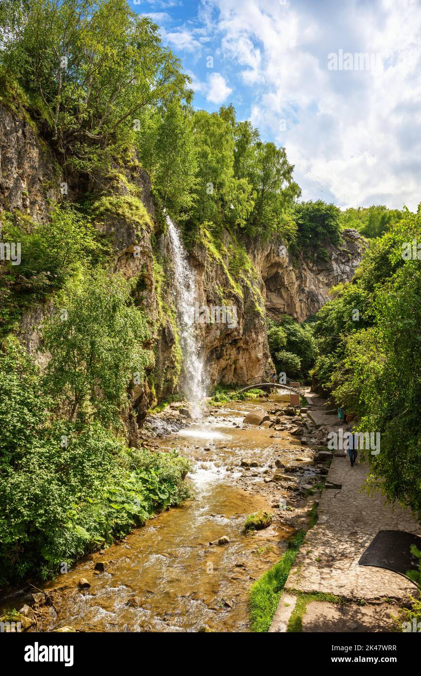 Wasserfall in Kislowodsk, Russland. Im Sommer fällt Wasser in Schlucht, Berglandschaft mit Felsen, Schlucht, Himmel und Bäumen. Thema Natur, Reisen, Wandern Stockfoto