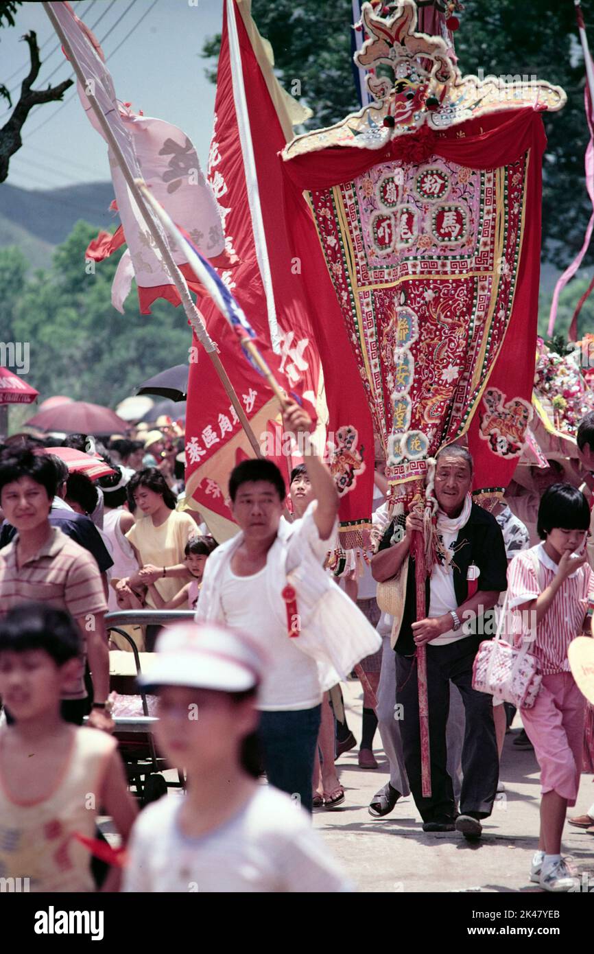 Vertikale Aufnahme eines älteren Mannes mit einem „Pai Lau“-Banner (aus dem Dorf Ma Mei Ha) beim Tin Hau Temple Festival, Ping Yeung Village, Ta Kwu Ling, New Territories, Hongkong 1985 Stockfoto