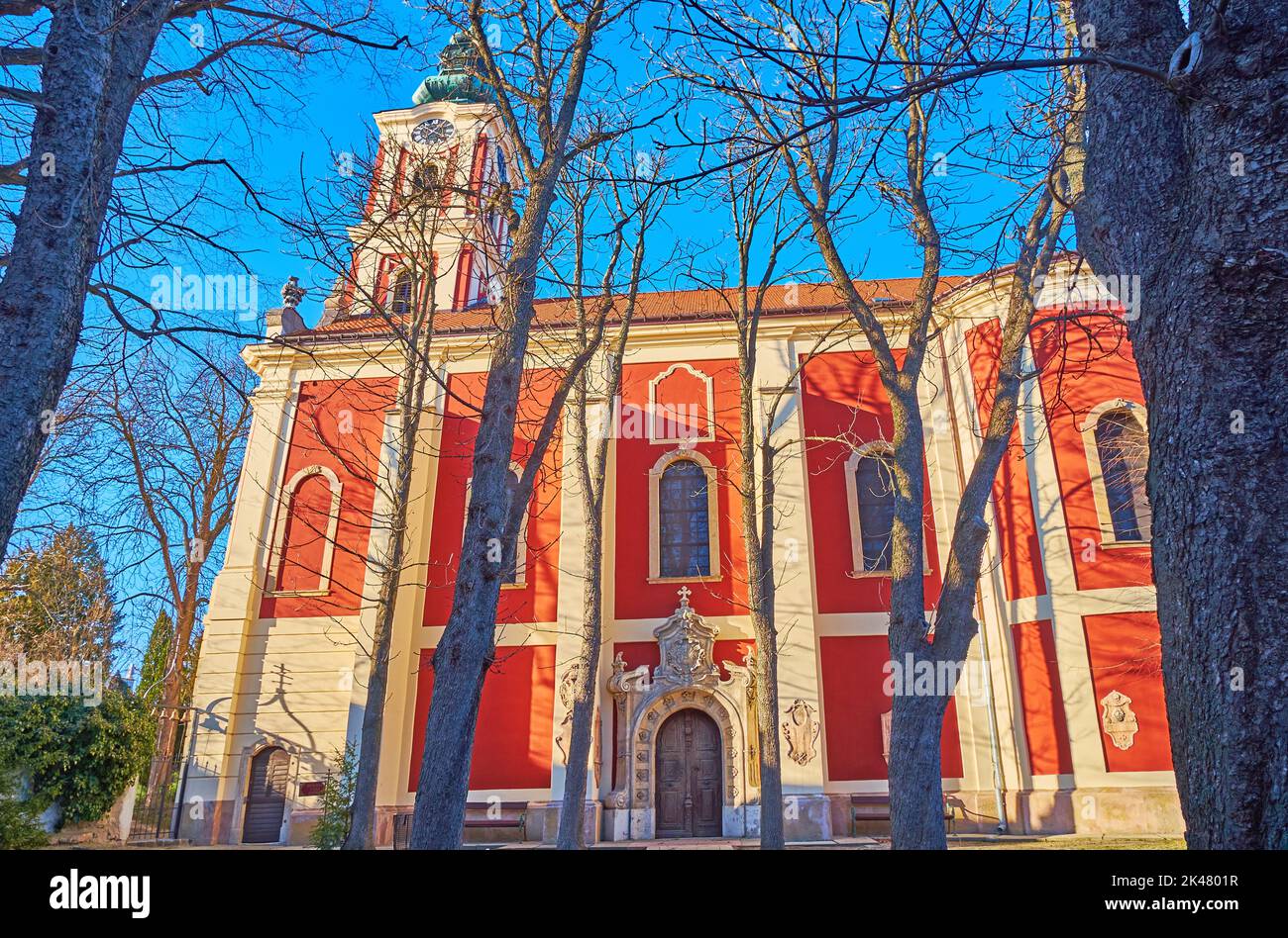 Die leuchtend rote Fassade der Serbisch-orthodoxen Kathedrale von Belgrad (Saborna), umgeben von einem alten Park, Szentendre, Ungarn Stockfoto