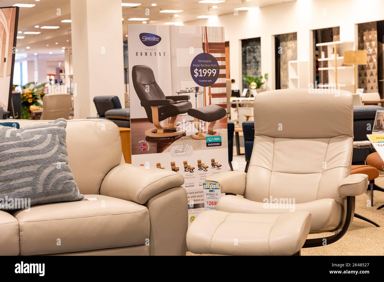 Harvey Norman Domayne Möbelgeschäft, stressfreier Ledersessel i beigefarbenes Leder mit Fußhocker, auch zwei-Sitzer-Sofa, Sydney, Australien Stockfoto