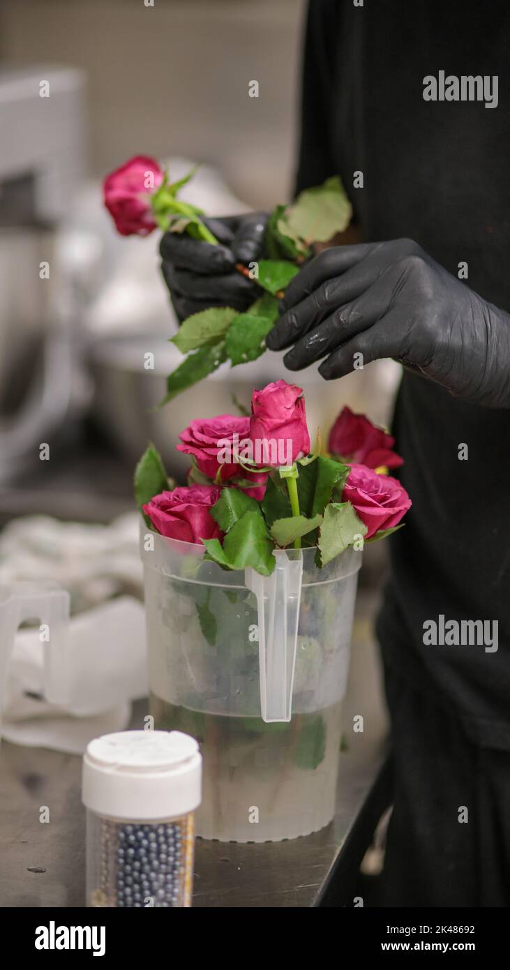 Echte Rosen für eine Hochzeitstorte Dekoration in der Küche Stockfoto