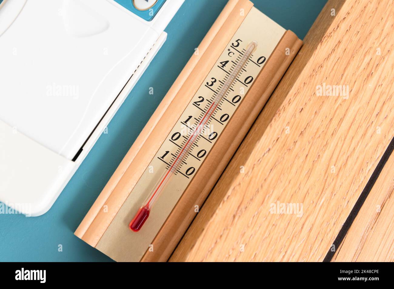 Haushaltsalkoholthermometer, das die Temperatur in Grad Celsius anzeigt, befindet sich an der blauen Wand, Nahaufnahme Stockfoto