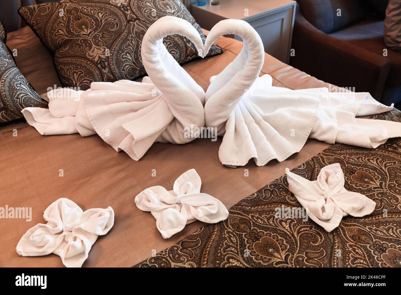 Schwäne aus weißen Handtüchern, romantische Zimmerdekoration einer Honeymoon-Suite Stockfoto