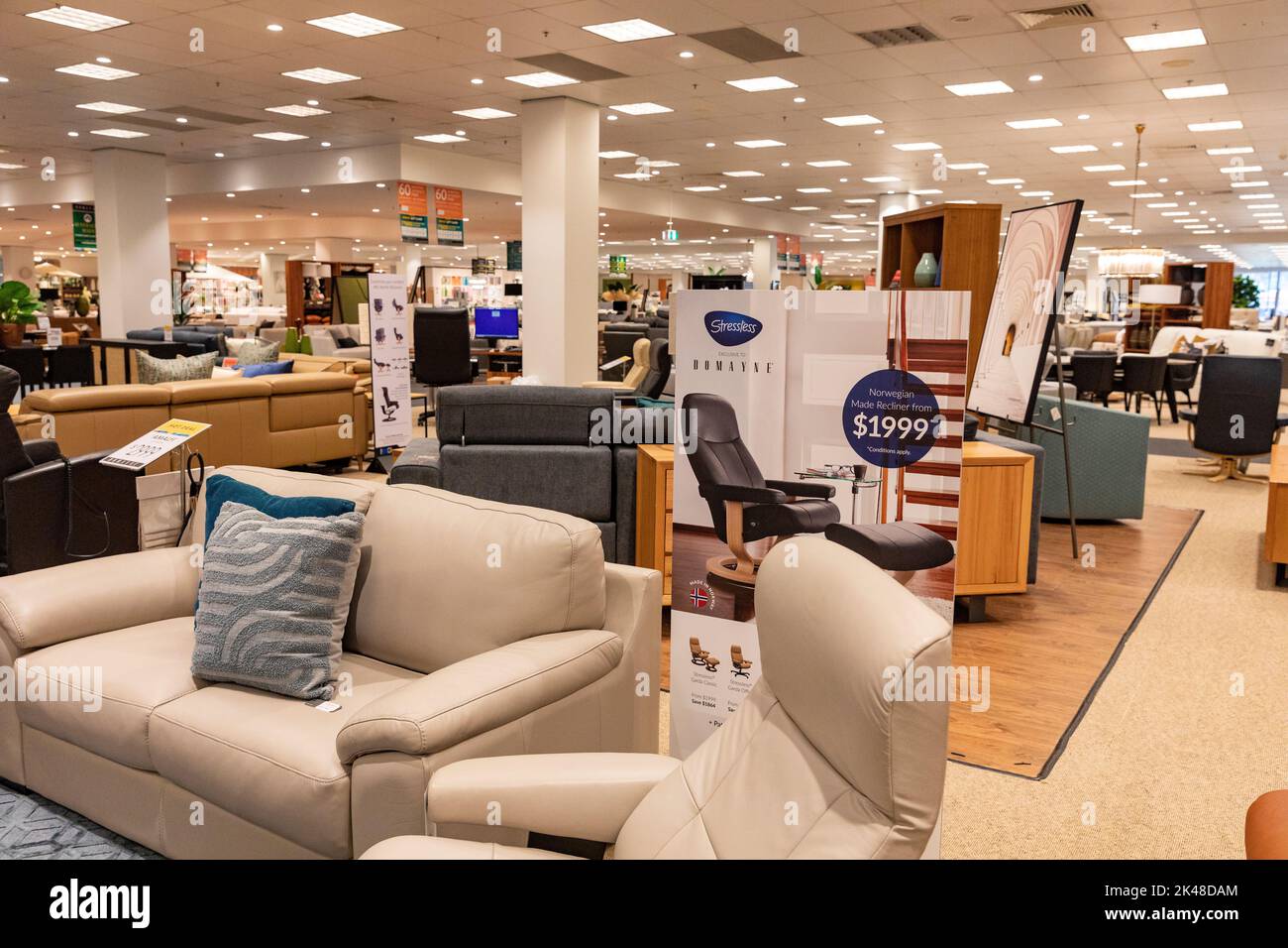 Harvey Norman Domayne Möbelgeschäft, stressfreier Ledersessel in beigem Leder mit Fußhocker, auch zweisitzige Sofa-Sofa, Sydney, Australien Stockfoto