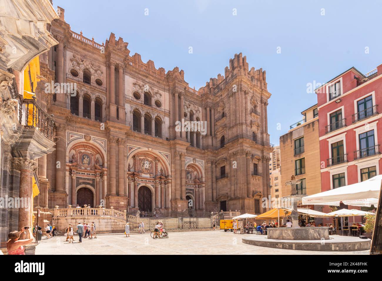 Blick auf die Fassade der Kathedrale von Malaga oder Santa Iglesia Catedral Basílica de la Encarnación, mit einem Brunnen und Touristen auf dem Stadtplatz Stockfoto