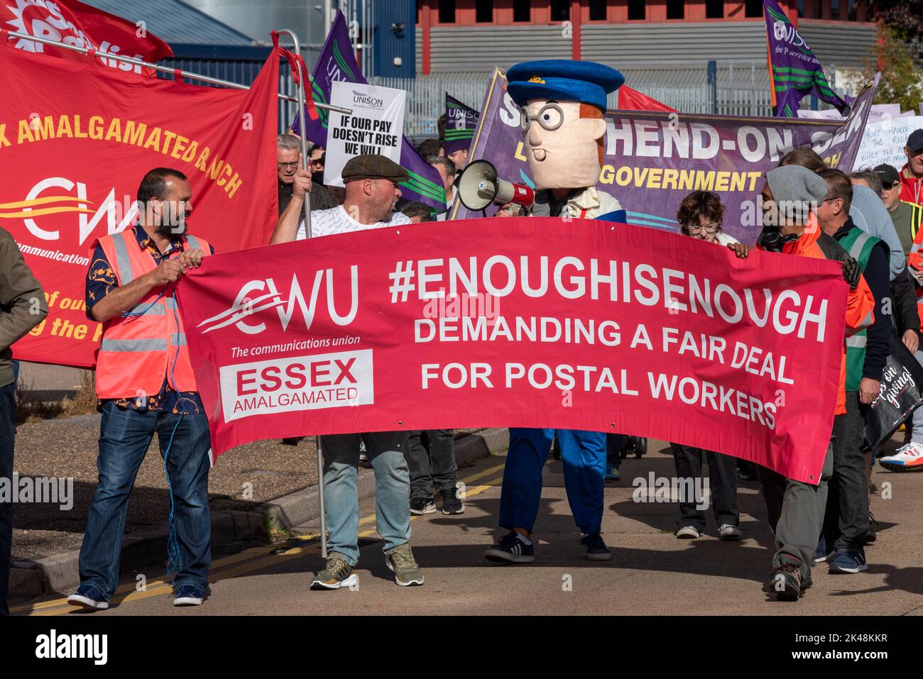 Southend on Sea, Essex, Großbritannien. 1. Oktober 2022. Im ganzen Land finden Proteste statt, um die Lebenshaltungskosten, die Bezahlung der Arbeiter und die Solidarität mit den Streikenden hervorzuheben. In Southend schlossen sich die Streikenden auf der Streiklinie der CWU vor dem Sortierbüro Short Street Royal Mail mit den Eisenbahnstreikern von ASLEF und RMT zusammen, bevor sie sich den Demonstranten in der High Street anschließen. Genug ist genug Banner, mit Postarbeitern im Postmann Pat Kostüm Stockfoto