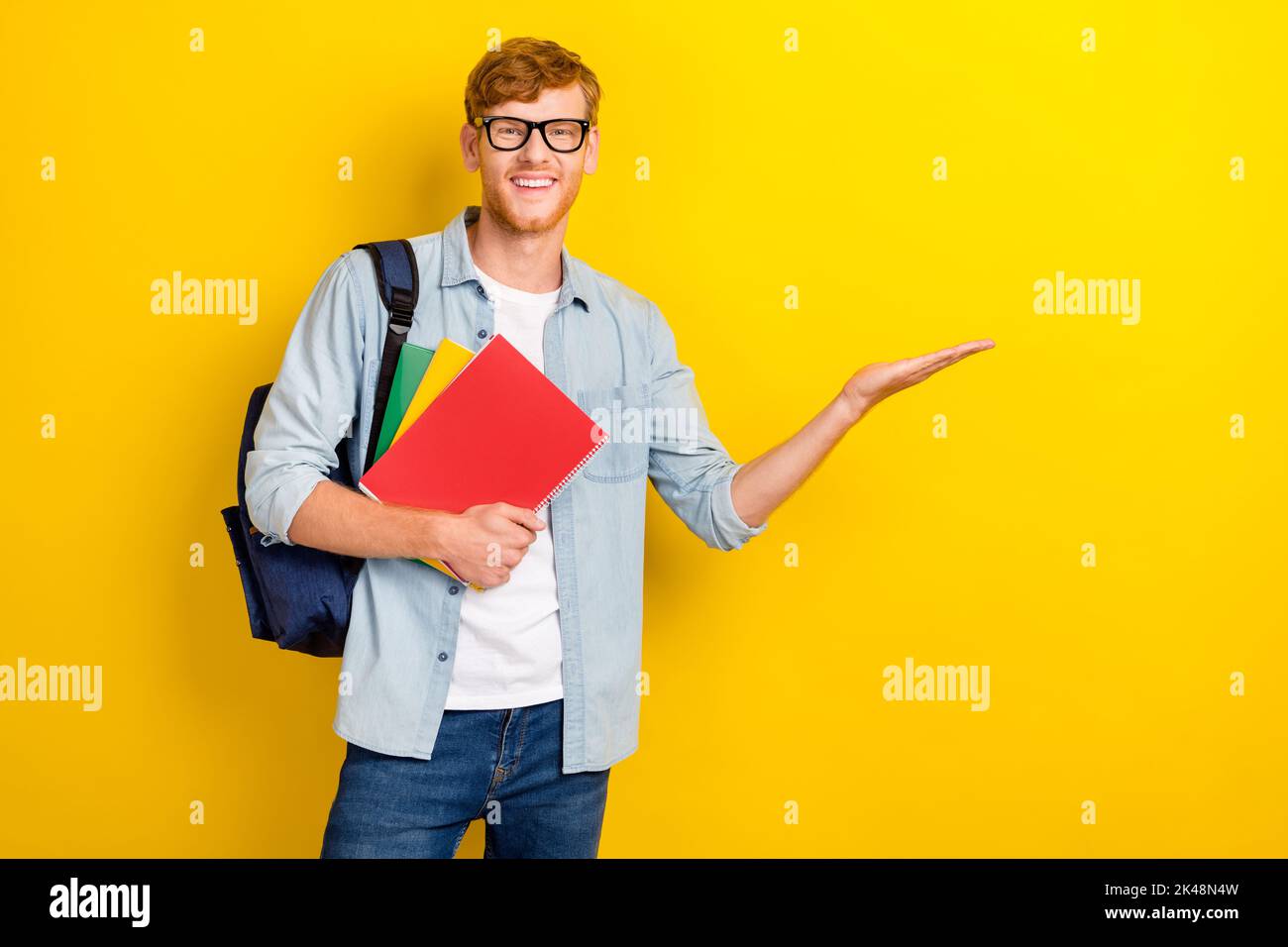 Portrait Foto von jungen attraktiven Studenten Universität halten Bücher empfehlen App für das Studium isoliert auf gelbem Hintergrund Stockfoto