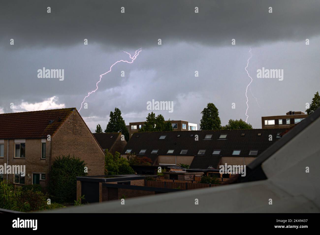 Dunkler Himmel mit Blitzeinschlägen über eine Stadt Stockfoto