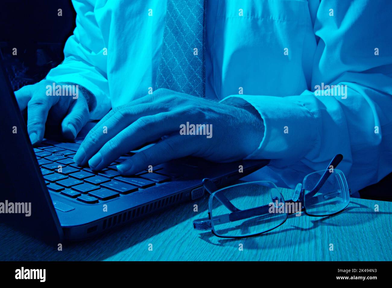 Cyber-Sicherheitsanalyst, der Computer in blauem Licht verwendet Stockfoto