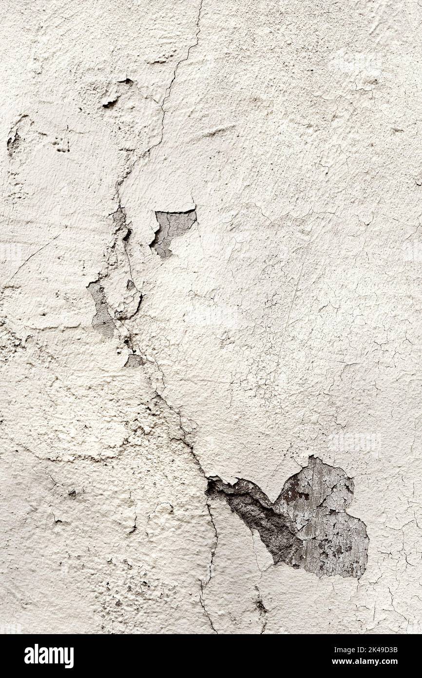 Weiß lackierte rissige verputzte Wand mit Rissen. Alte verzweifelte Schadensfläche. Hochauflösendes Hintergrundbildelement mit Kopierraum, Textplatz. Stockfoto