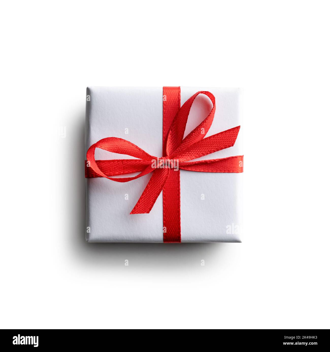 Weiße Geschenkbox mit roter Schleife isoliert auf weißem Hintergrund. Kreatives Postkarten-Design für Weihnachten und Valentinstag Stockfoto