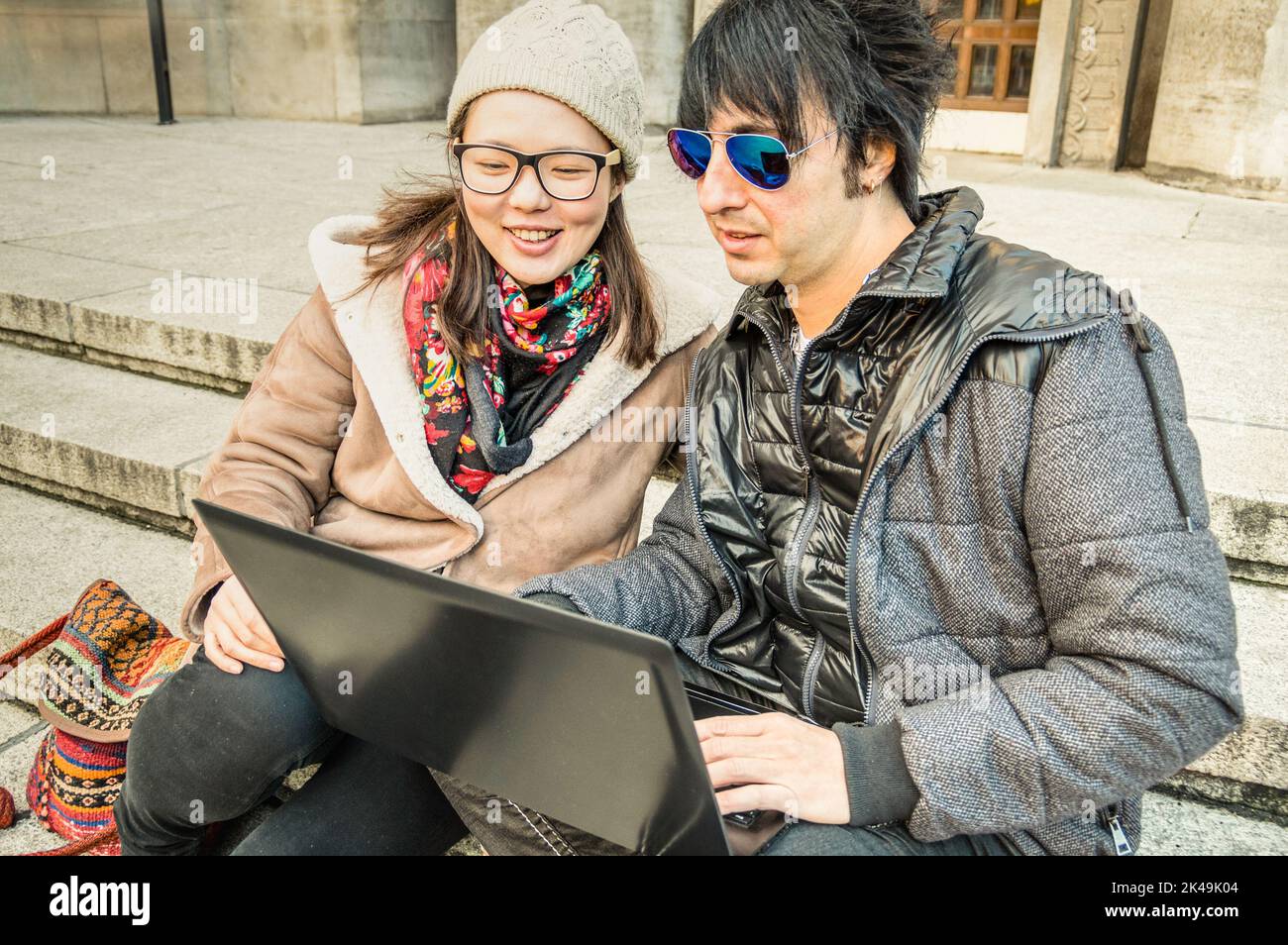 Multirassisches Paar, das Spaß mit dem Laptop hat - modernes Konzept der Verbindung mit Computertechnologie - städtischer Lebensstil und Beziehung zum Alltag - Stockfoto